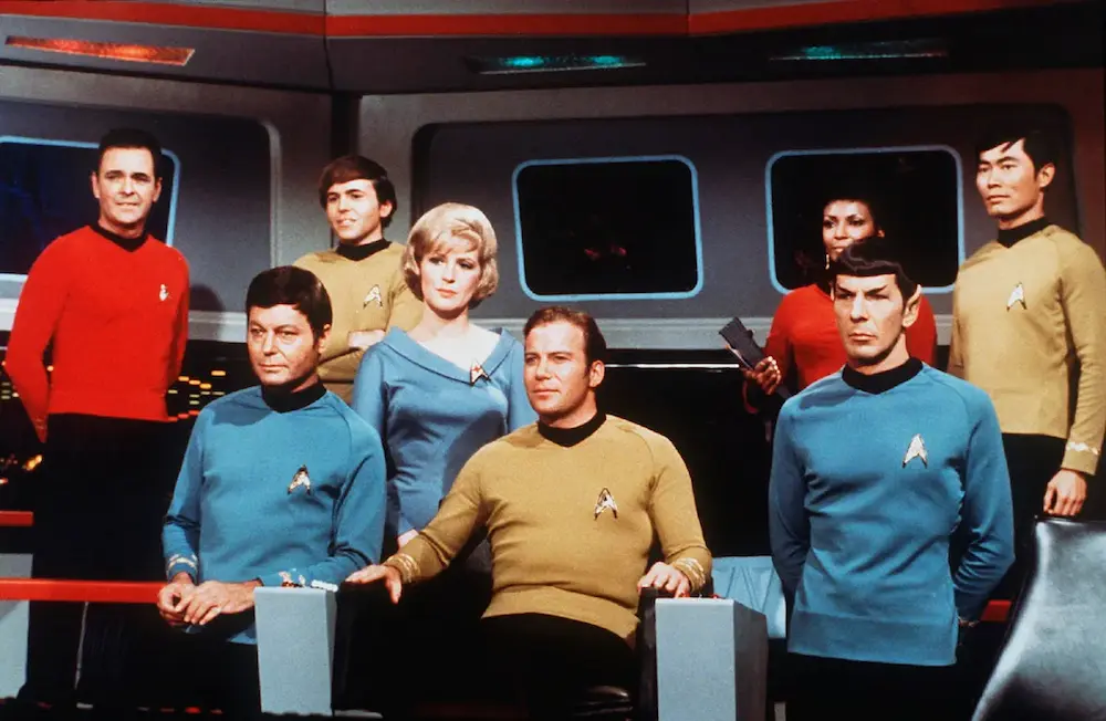 Promotional photo of the original Star Trek cast on the bridge of the Enterprise, including Captain Kirk, Spock, Uhura, and others—representing a major milestone in televised science fiction.